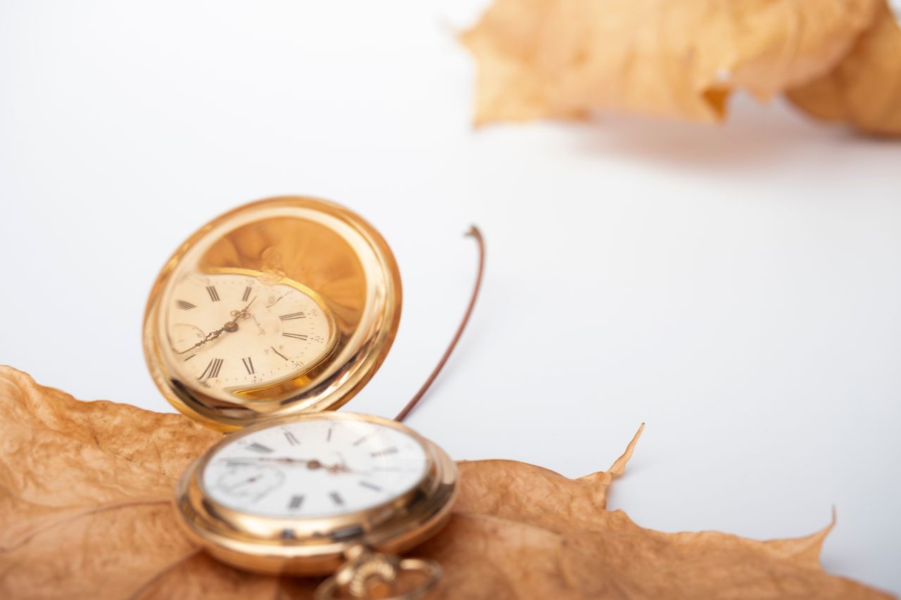 About Elegant gold pocket watches resting on dry autumn leaves, symbolizing the passage of time.
