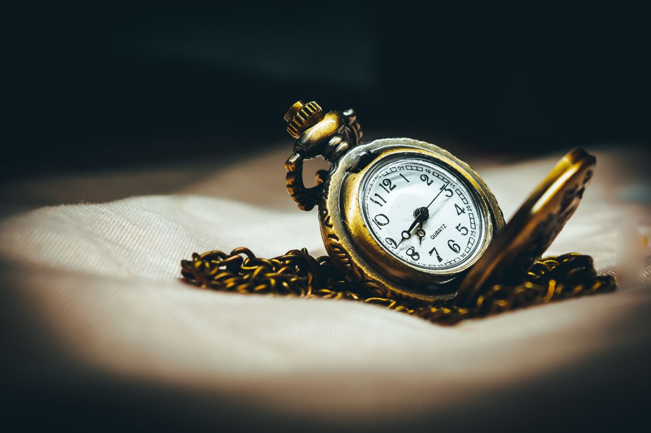 Crafting Captivating Headlines: Your awesome post title goes here Close-up of a vintage brass pocket watch with a chain on white fabric, evoking nostalgia and timeless elegance.